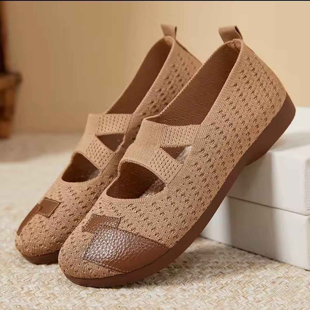 Slip-on shoes in warm beige knit with medium brown soles and pebbled toe overlay.