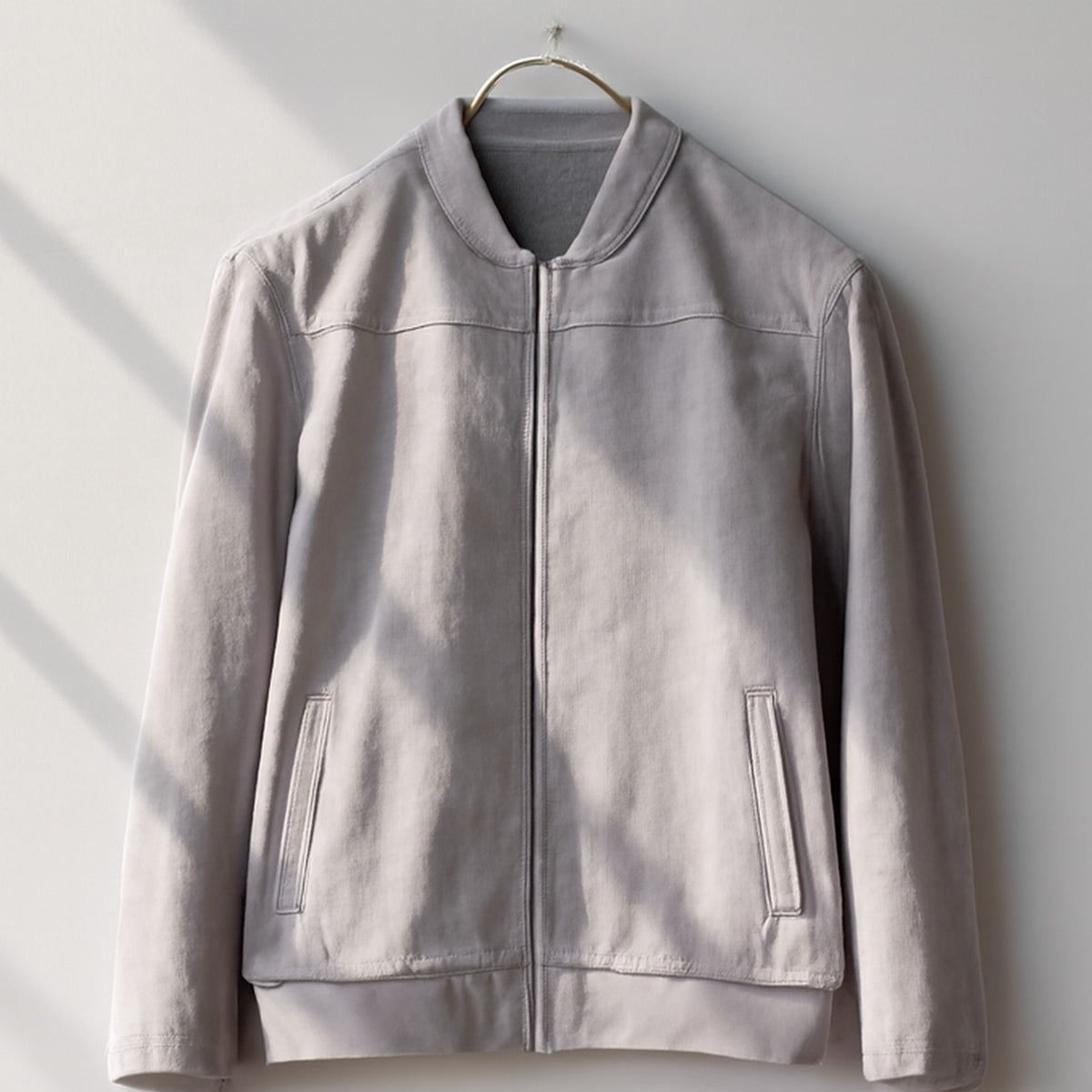 Bomber jacket in light gray with matte finish and silver zipper.